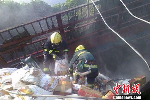 8月1日6時左右，滬昆高速上饒段一貨車側(cè)翻著火，駕駛室燒成空殼。圖為消防官兵清理現(xiàn)場。吳兵章 攝